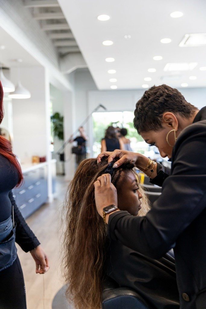 Salon stylist braiding and installing extensions at Rose Style Studio
