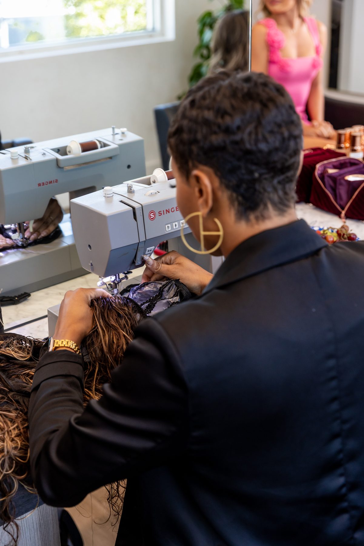 Stylist sewing a weft on a Singer machine at Rose Style Studio