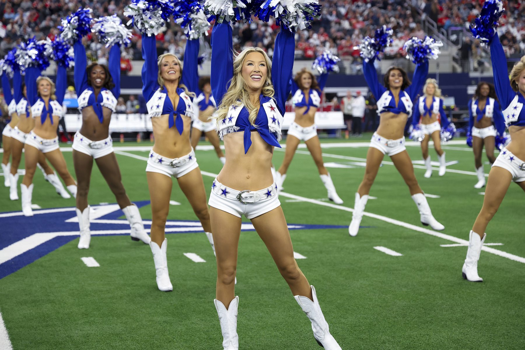 Dallas Cowboys Cheerleaders celebrating on the stadium turf