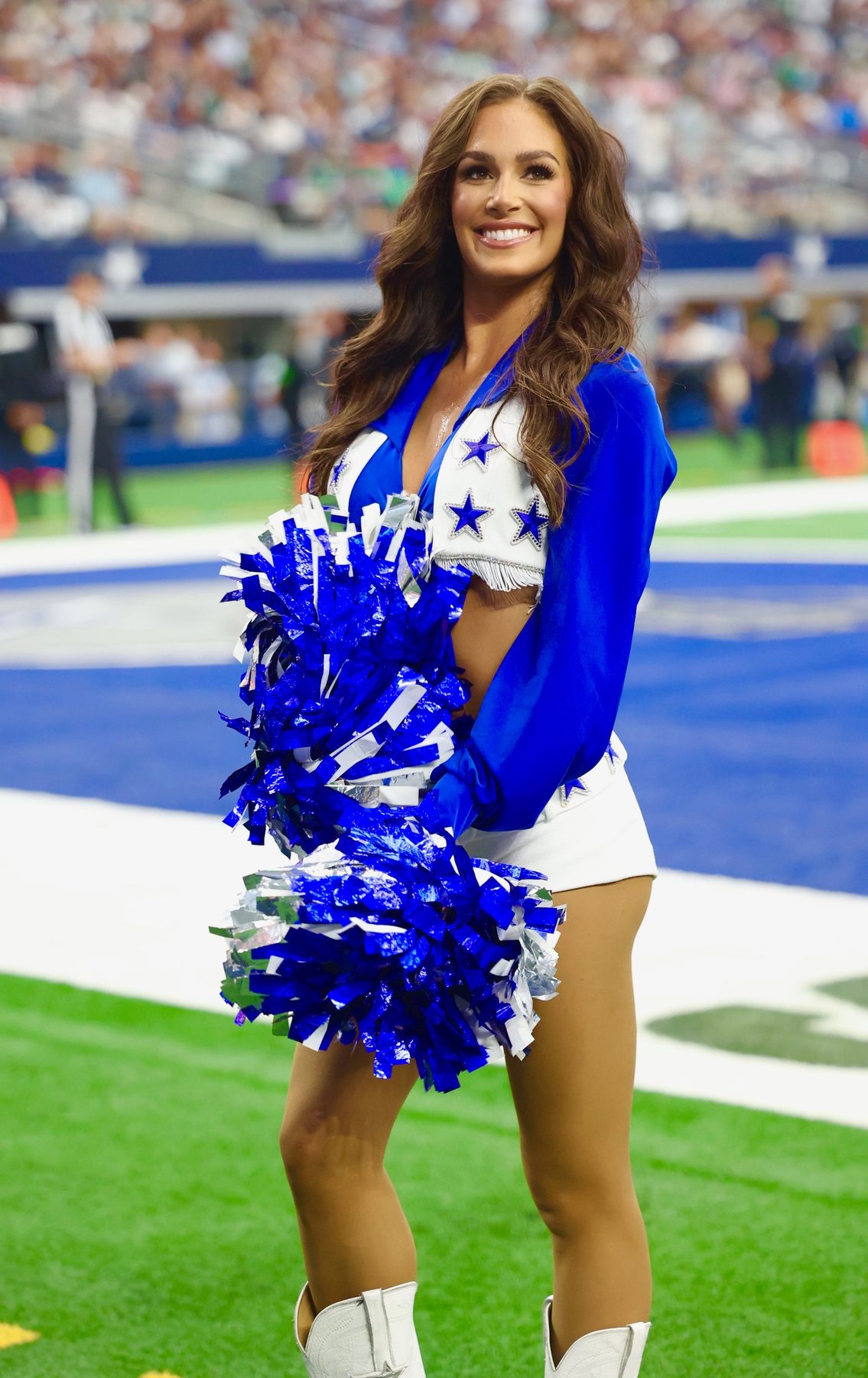 Dallas Cowboys Cheerleader on the sideline with pom-poms